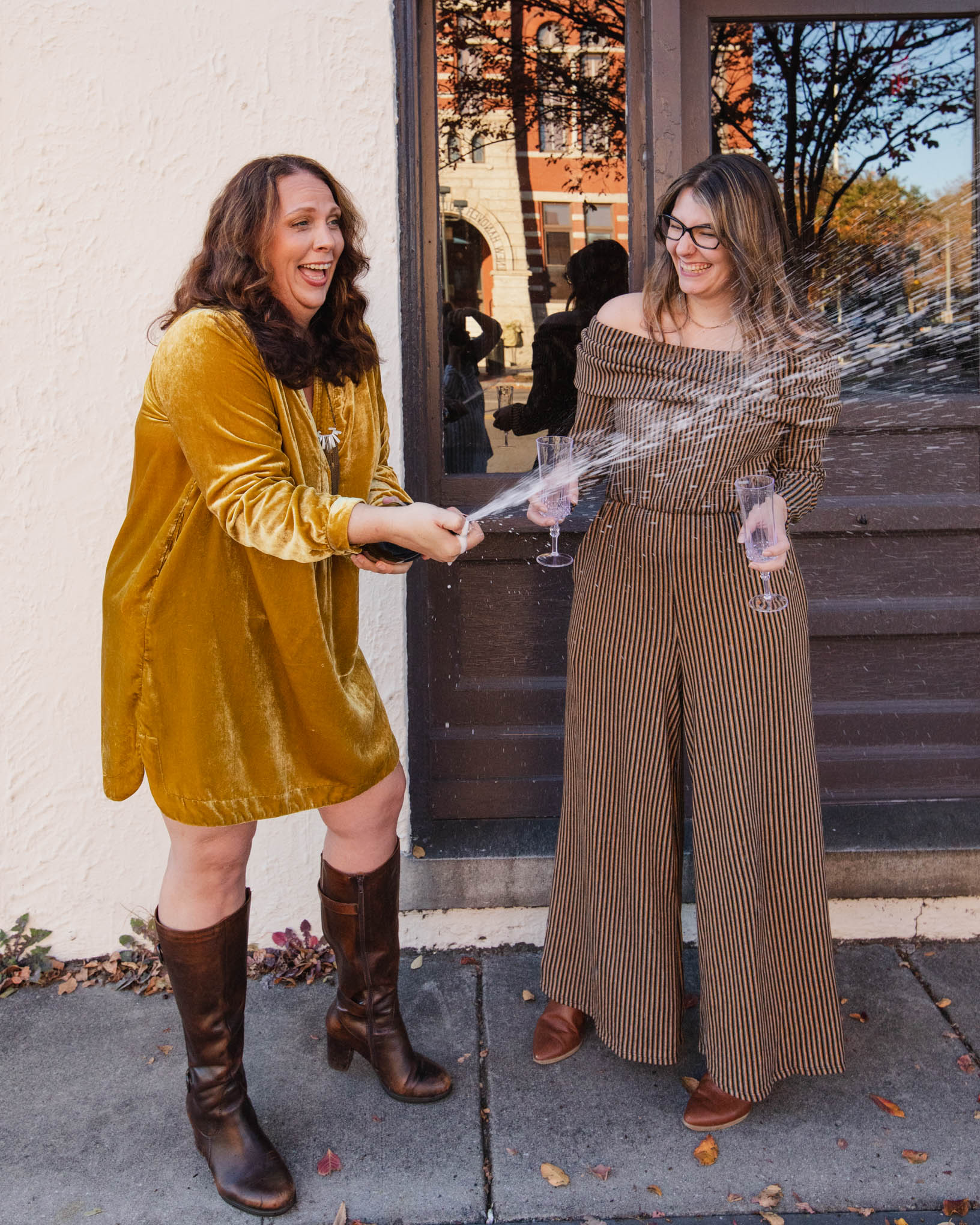 Samm Sawyer and Andrea Arth, a featured client, popping a champagne bottle together